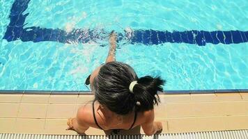 Caucasian pretty attractive woman in black bikini sit by swimming pool in hotel resort on holiday vacation. Tourist enjoy sun, sunbathing relax by pool in hot sunny day in Cyprus video