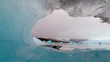 stänga upp zoom ut Timelapse fjällsjökull glaciär i mulen dag i island med vatten droppar. de underbar glaciär lagun av fjallsrln i island video