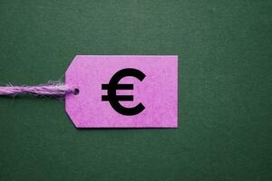 euro symbol in the pink price tag on the green background photo