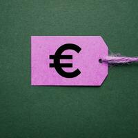 euro symbol in the pink price tag on the green background photo