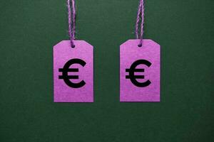 euro symbol in the pink price tag on the green background photo