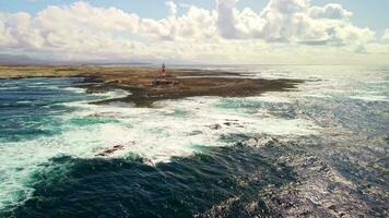 nadering naar de vuurtoren, een mooi landschap met golven en zee schuim. video