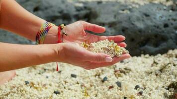 The girl picks up small white volcanic stones, close up. video