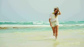 The girl runs along the beach, approaches. White sand and blue sea. video