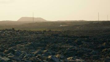 The car drives through the volcanic terrain at sunset video