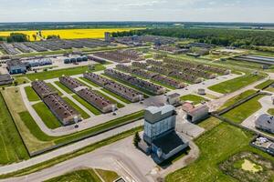 aerial panoramic view over livestock farm and agro-industrial complex with silos and rows of barns, pigsties, chicken coops photo