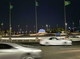 Jeddah, Saudi Arabia, June 2023 - A beautiful view of Saudi Arabian flags flying at Jeddah Corniche Road intersection at night. photo