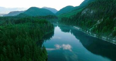 Aerial view of Elbow Lake and mountains in spring. Fog creeps over the water video