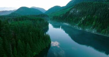 Aerial view of Elbow Lake and mountains in spring. Fog creeps over the water video