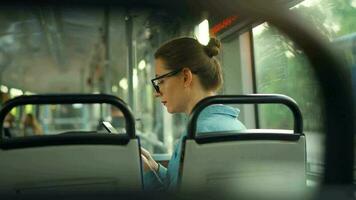 público transporte. mujer en lentes en tranvía utilizando teléfono inteligente video