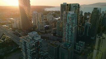 vuelo a lo largo el calle Entre rascacielos a puesta de sol. vancouver, Canadá. video