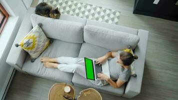 Overhead view of woman reading the book, lying on couch at home video