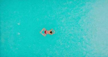 Top down view of a man in red shorts swimming in the pool, slow motion. video