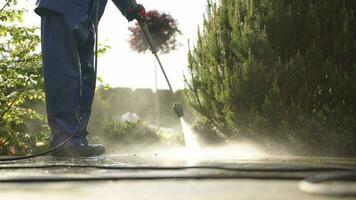 schoonmaak steen bestrating in een tuin gebruik makend van macht wasmachine. video