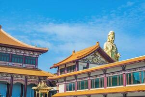 Guanyin goddress with temple rooftop and beautiful sky at foguangshan thaihua temple thailand.Fo Guang Shan is one of the four large Buddhist organizations in Taiwan photo