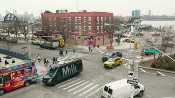 Manhattan, New York, USA - 3-17-2023 - High angle view of busy intersection near Liberty Inn on 10th avenue and 14th street with moderate traffic and pedestrians crossing video