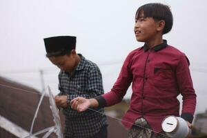 Magelang Indonesia 16 June 2023- Indonesian children playing kites in the mountains. photo