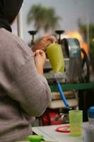 The hands of an Indonesian street vendor preparing a glass of sugar cane juice. photo