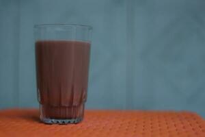Chocolate milk in a transparent glass cup photo