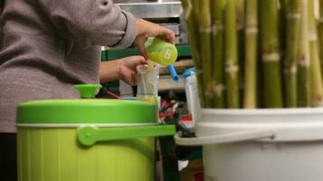 The hands of an Indonesian street vendor preparing a glass of sugar cane juice. photo