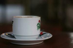 black coffee in a white mug on a wooden table photo