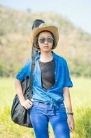 woman wear hat walking and carry her guitar bag photo