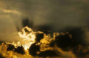 Image of sun shine through rain cloud photo