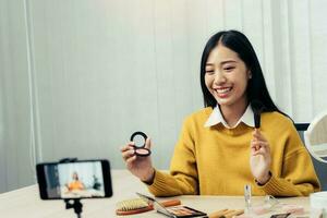 Young Asian beauty blogger is showcasing cosmetic products as well as tutorials on how to apply and record makeup tutorials on social media networks. photo