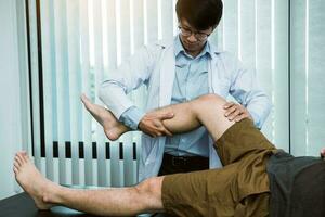 Physiotherapists are using the hands to grip the patient thigh to check for pain and massage in the clinic. photo