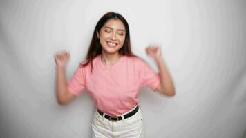 dansen gelukkig jong vrouw vervelend roze overhemd studio met wit achtergrond. video
