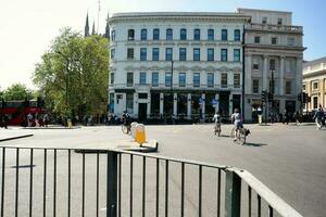 Beautiful Low Angle View of Central London and Road with Traffic and People. The Image Was Captured at Tower Bridge London England Great Britain on Warm Sunny Day of 04-June-2023 photo