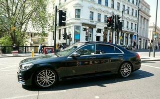 Beautiful Low Angle View of Central London and Road with Traffic and People. The Image Was Captured at Tower Bridge London England Great Britain on Warm Sunny Day of 04-June-2023 photo