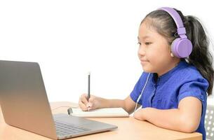 contento niña estudiante haciendo deberes con auricular y disfrutar en línea aislado foto