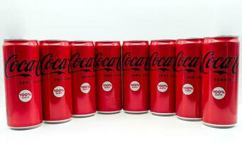 Bologna Italy  November 11, 2022 Row of Coca Cola can isolated on white background. photo