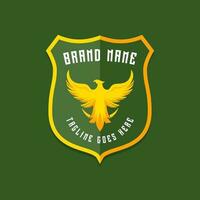 Military eagle logo on yellow green shield. Patriotic animal logotype vector illustration.