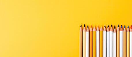 A row of colored pencils on a yellow background created with technology photo