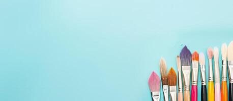A row of colorful paint brushes on a blue background created with technology photo