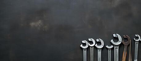 A group of wrenches sitting on top of a black wall created with technology photo