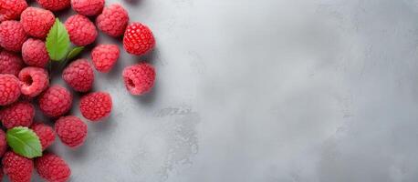 A bunch of raspberries with leaves on a gray background created with technology photo