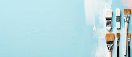 A group of paint brushes sitting on top of a blue surface created with technology photo