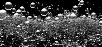 Soda water bubbles splashing underwater against black background. photo