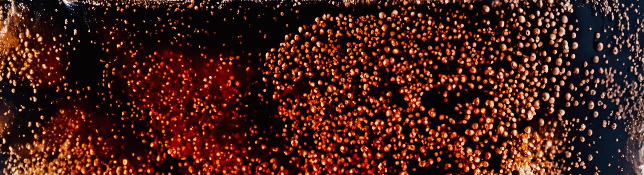 Cola with Ice. Close up of the ice cubes in cola water. Texture of carbonate drink with bubbles in glass. Cola soda and ice splashing fizzing or floating up to top of surface. Cold drink background. photo