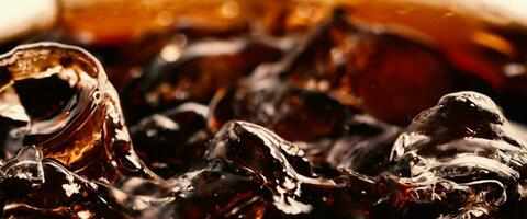 Splashing of Cola and Ice. Cola soda and ice splashing fizzing or floating up to top of surface. Close up of ice in cola water. Texture of carbonate drink with bubbles in glass. Cold drink background photo