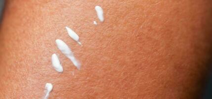 Close up of Sunscreen Protection or Sun Cream on human skin. photo