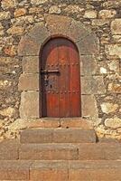 old wooden door with metal fittings in a stone building creating a background with stairs photo