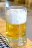 Butter beer in a glass with white foam. photo