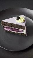 Delicious fresh blueberry or blackcurrant cake with cream cheese on a dark concrete background video