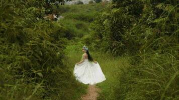 a royal princess in a white dress running in the middle of a forest full of green trees and bushes video