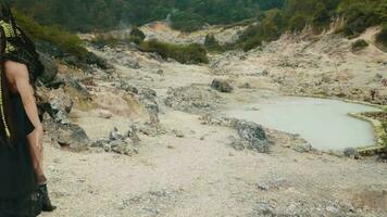 a witch in a black costume walks in a valley full of limestone video