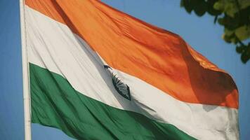 Indien-Flagge, die hoch am Connaught-Platz mit Stolz auf den blauen Himmel fliegt, Indien-Flagge flattert, indische Flagge am Unabhängigkeitstag und Tag der Republik Indien, Schuss nach oben geneigt, indische Flagge schwenkend, Har Ghar Tiranga video